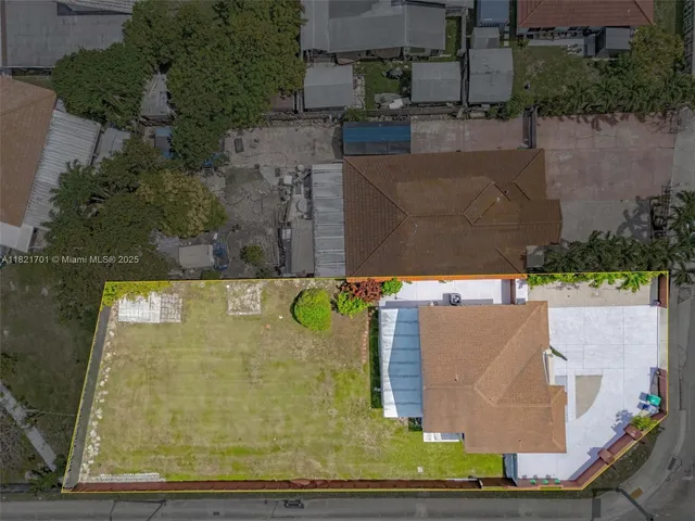 an aerial view of a city with lots of residential buildings ocean and mountain view in back