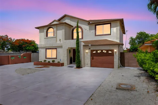a front view of a house with yard and parking