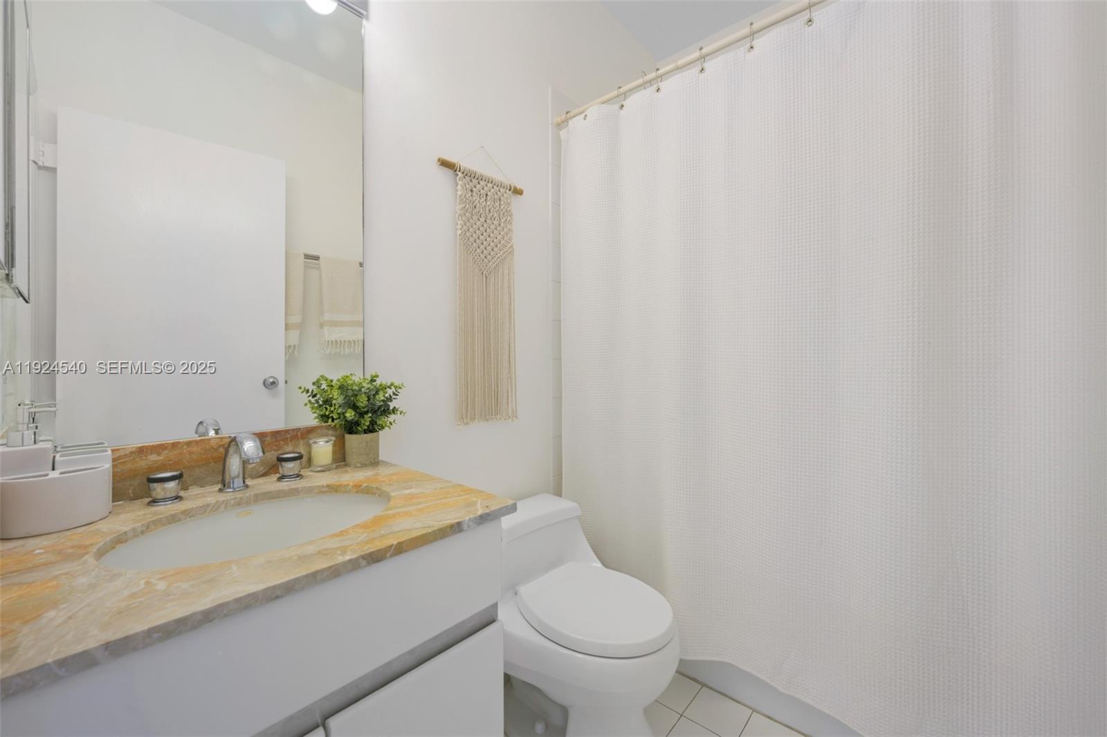 888 Brickell Key Drive, Unit 2909 Miami, FL 33131 - Photo 21 of 24 a bathroom with a granite countertop sink and a mirror