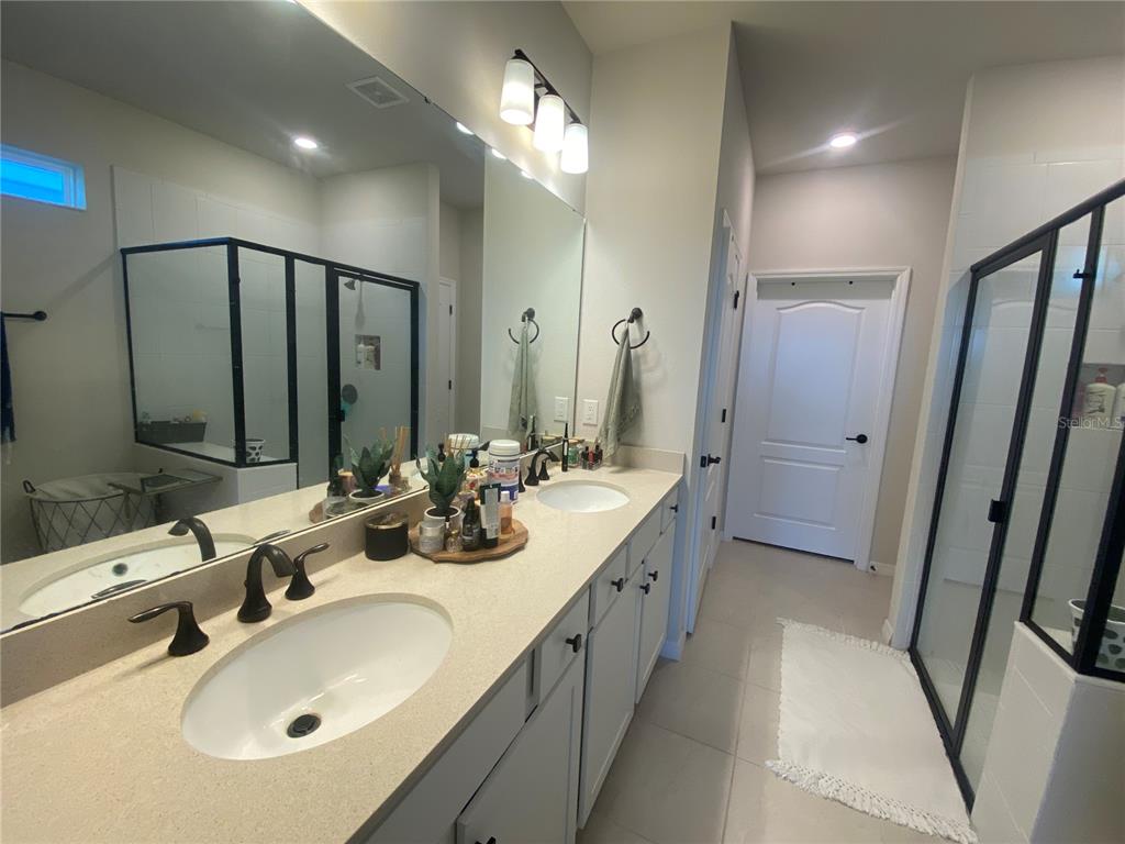 9610 Rally Spring Loop Wesley Chapel, FL 33545 - Photo 19 of 38 a bathroom with double vanity sink and a mirror