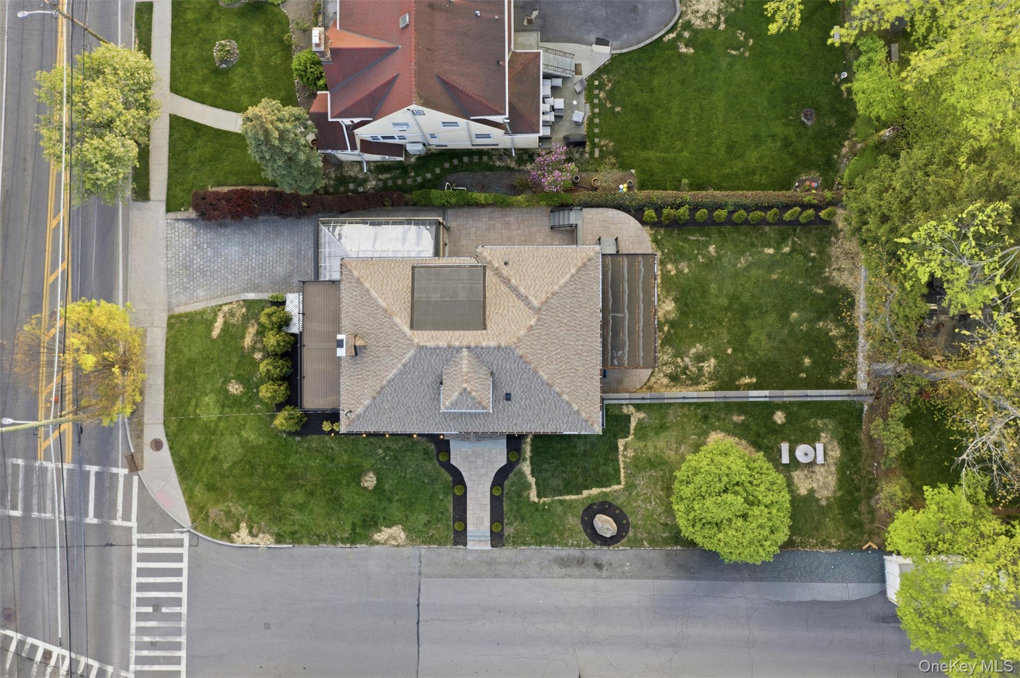 40 Calhoun Avenue New Rochelle, NY 10801 - Photo 43 of 49 Property featuring a grey shingled roof, a paved driveway, and an expansive grassy backyard