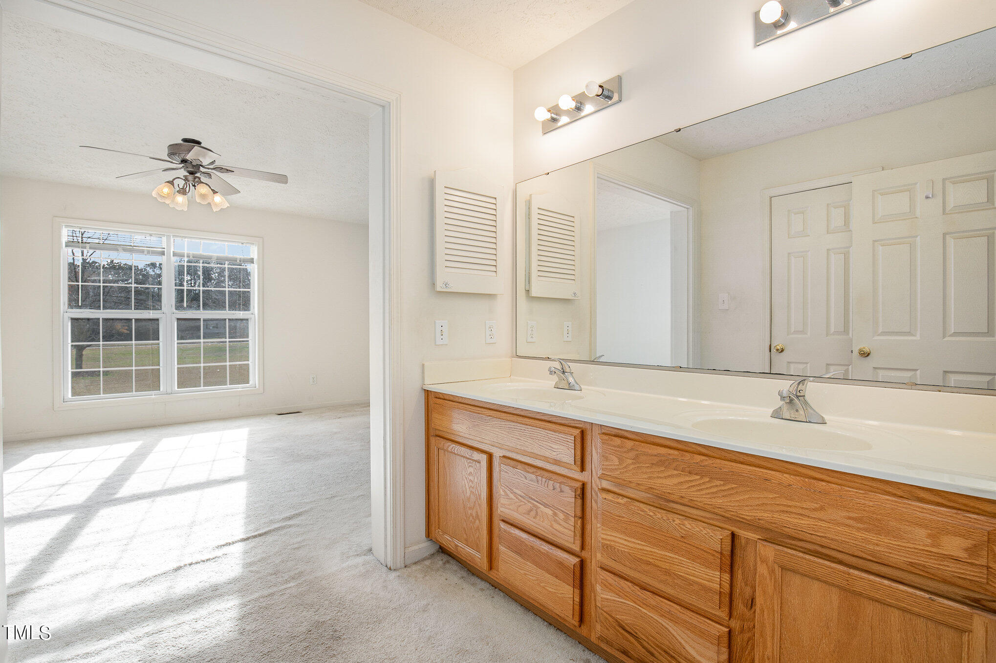 424 Henry Baker Road Zebulon, NC 27597 - Photo 12 of 26 a spacious bathroom with a double vanity sink large mirror and a bathtub