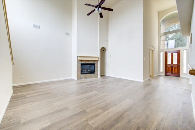 a view of empty room with a fireplace and wooden floor
