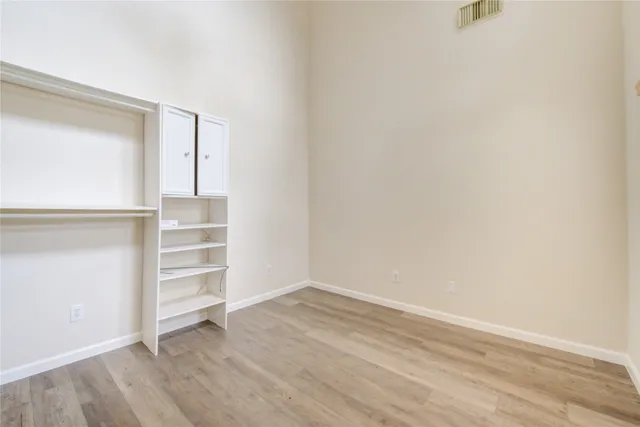 a view of walk in closet with empty racks