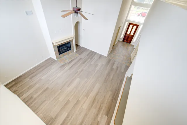 a view of a hallway with wooden floor and a window