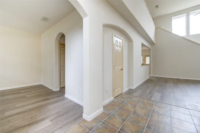 an empty room with entrance and windows