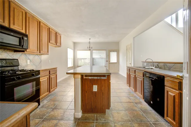 a kitchen with stainless steel appliances granite countertop a stove top oven a sink a counter space and cabinets