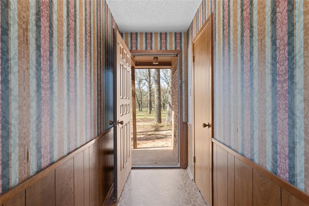 1447 Red Gate Road Mart, TX 76664 - Photo 26 of 38 a view of a hallway with wooden door and stairs