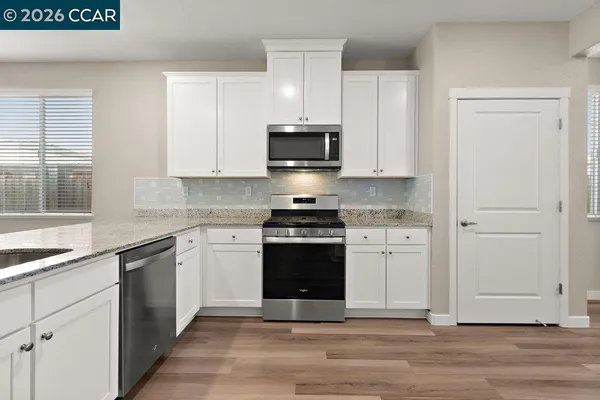 a kitchen with white cabinets and white appliances