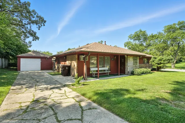 a front view of a house with a yard and trees