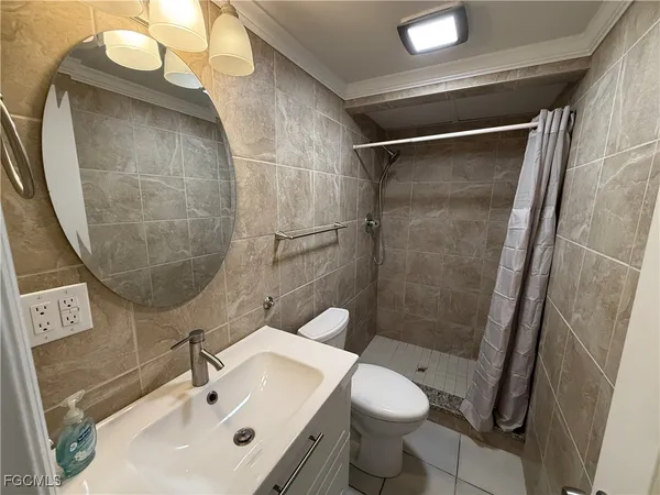 a bathroom with a sink mirror toilet and shower
