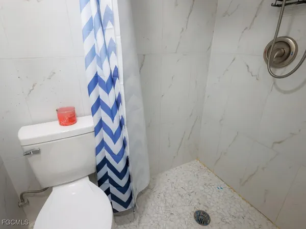 a bathroom with a toilet and a shower curtain