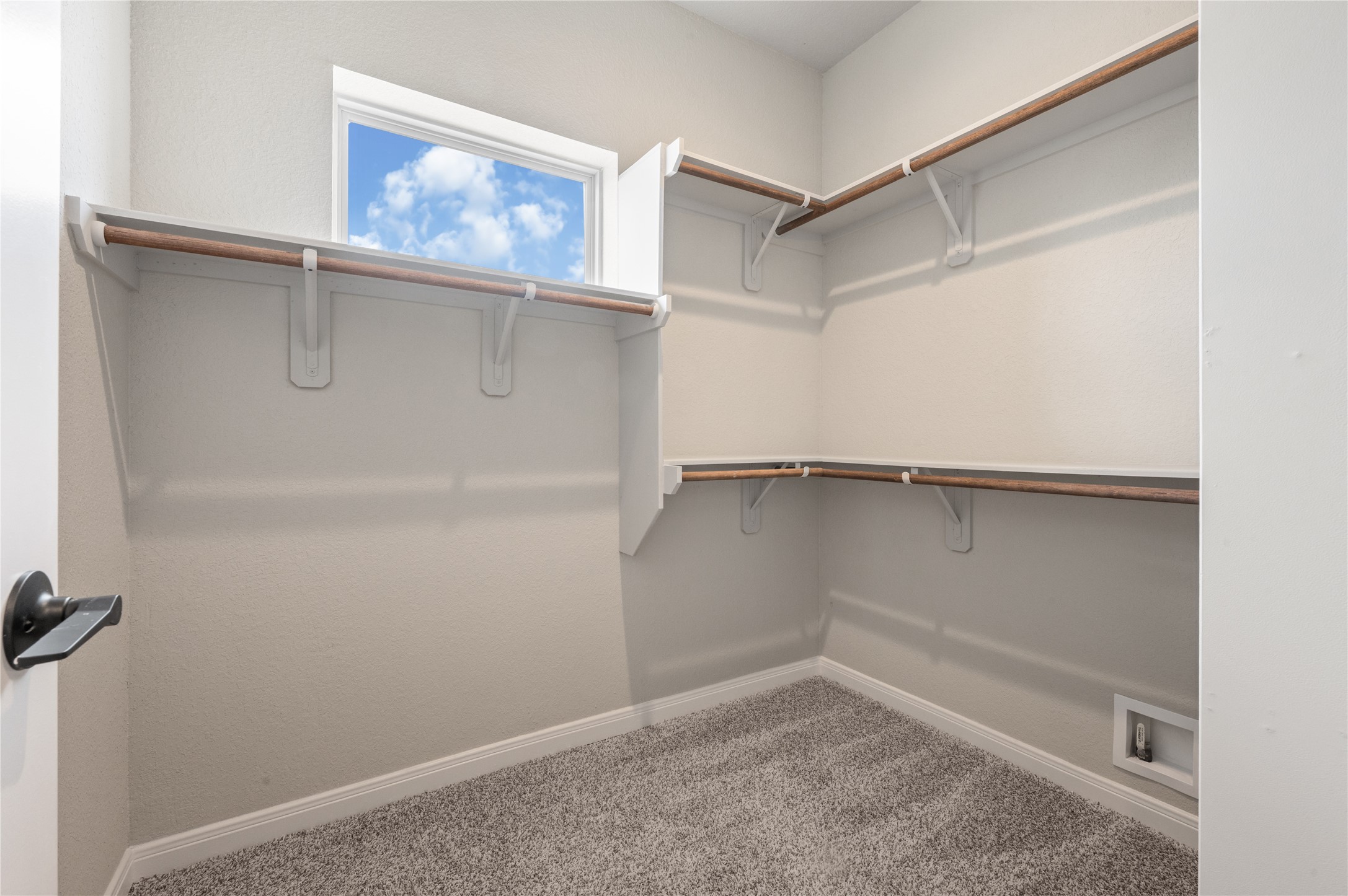 14010 Longstreet Road, Unit 2 Willis, TX 77318 - Photo 17 of 29 This is a spacious walk-in closet featuring multiple wooden shelves, bright natural light from a small window, and plush carpet flooring.