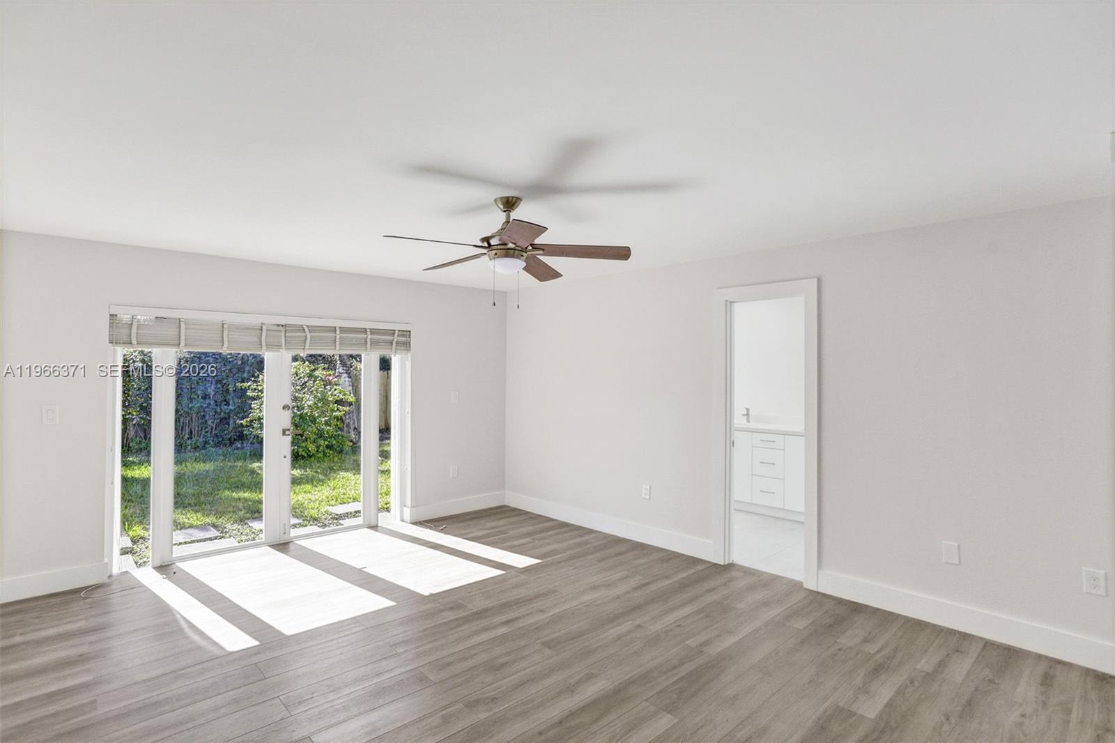 12020 Southwest 93rd Street Miami, FL 33186 - Photo 17 of 42 a view of an empty room with wooden floor and a window
