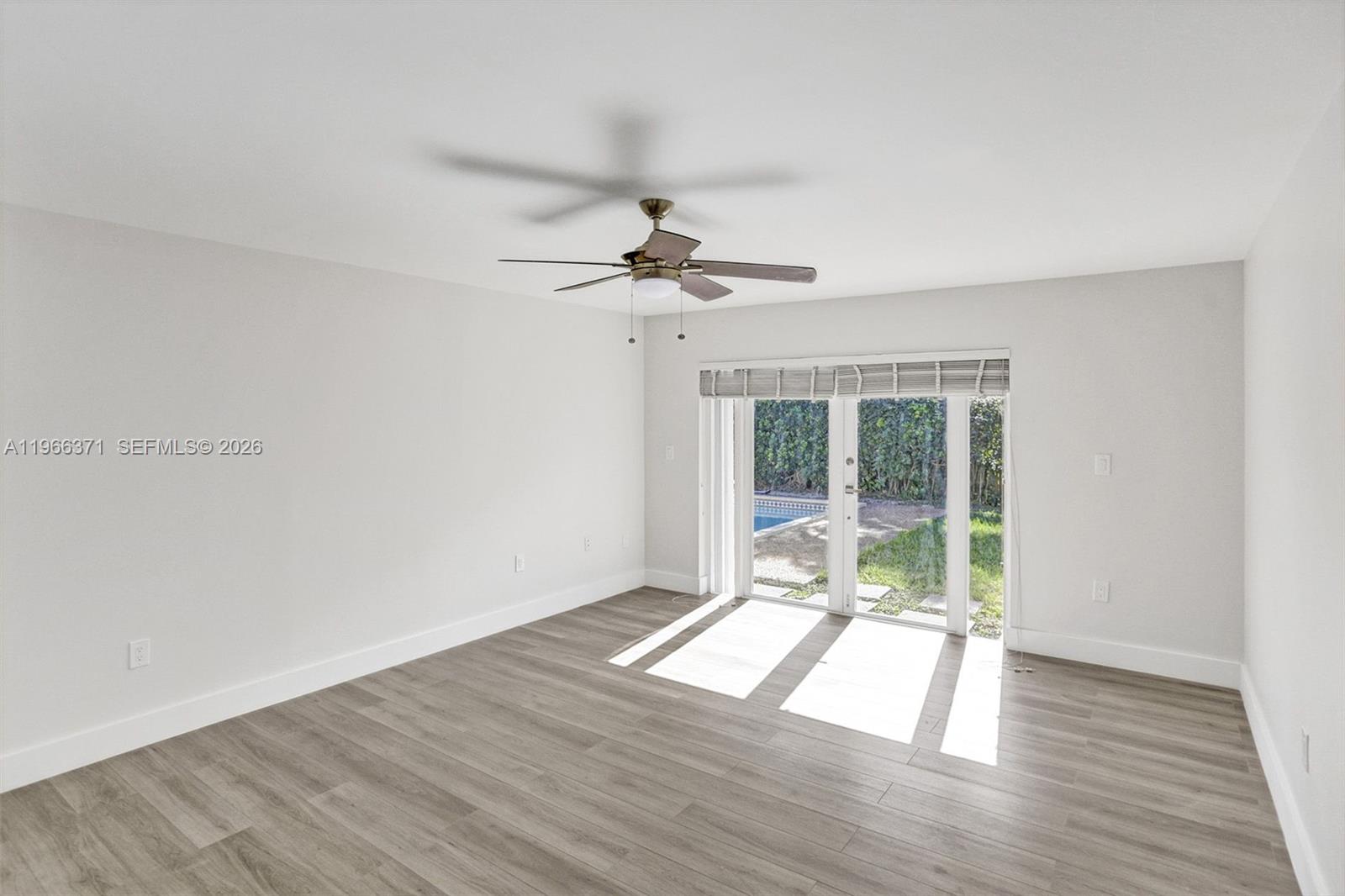 12020 Southwest 93rd Street Miami, FL 33186 - Photo 18 of 42 a view of an empty room with wooden floor and a window