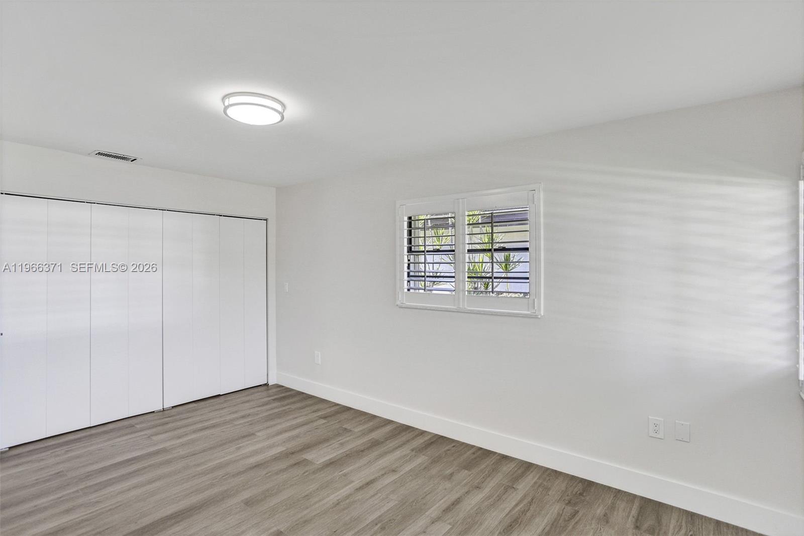 12020 Southwest 93rd Street Miami, FL 33186 - Photo 24 of 42 an empty room with wooden floor and windows