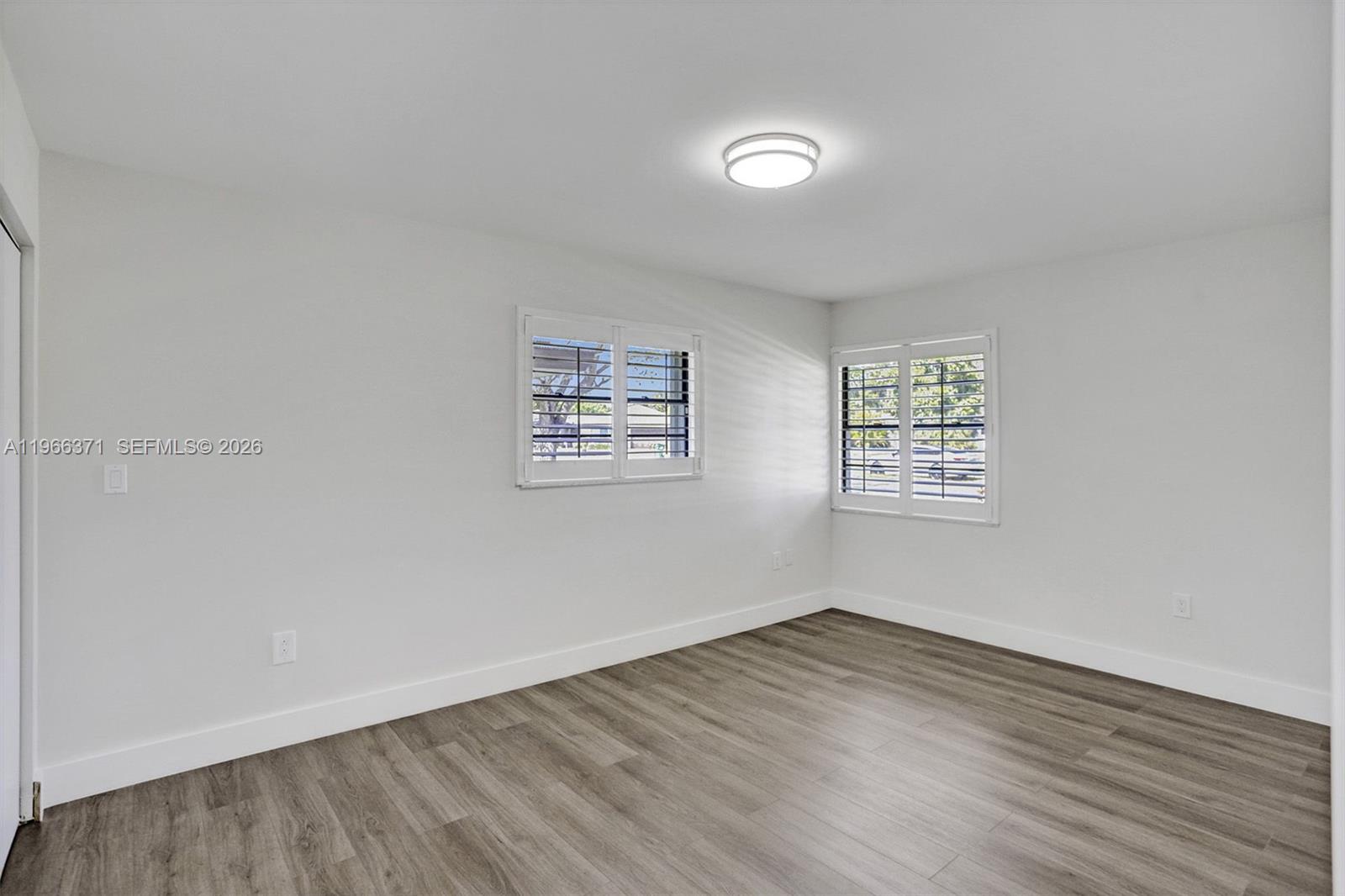 12020 Southwest 93rd Street Miami, FL 33186 - Photo 26 of 42 an empty room with wooden floor and windows