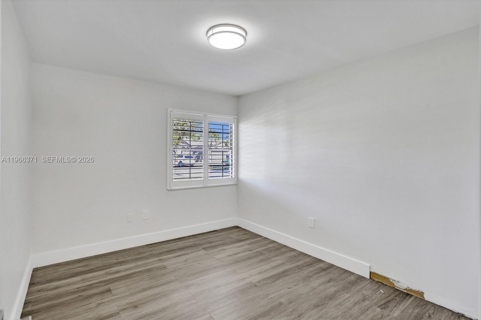 12020 Southwest 93rd Street Miami, FL 33186 - Photo 28 of 42 an empty room with wooden floor and windows