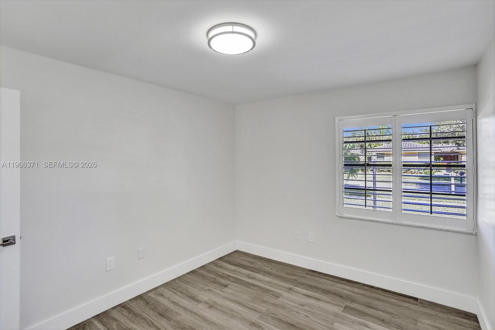 12020 Southwest 93rd Street Miami, FL 33186 - Photo 29 of 42 an empty room with wooden floor and windows
