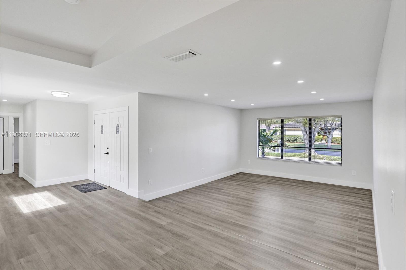 12020 Southwest 93rd Street Miami, FL 33186 - Photo 5 of 42 a view of an empty room with wooden floor and a window