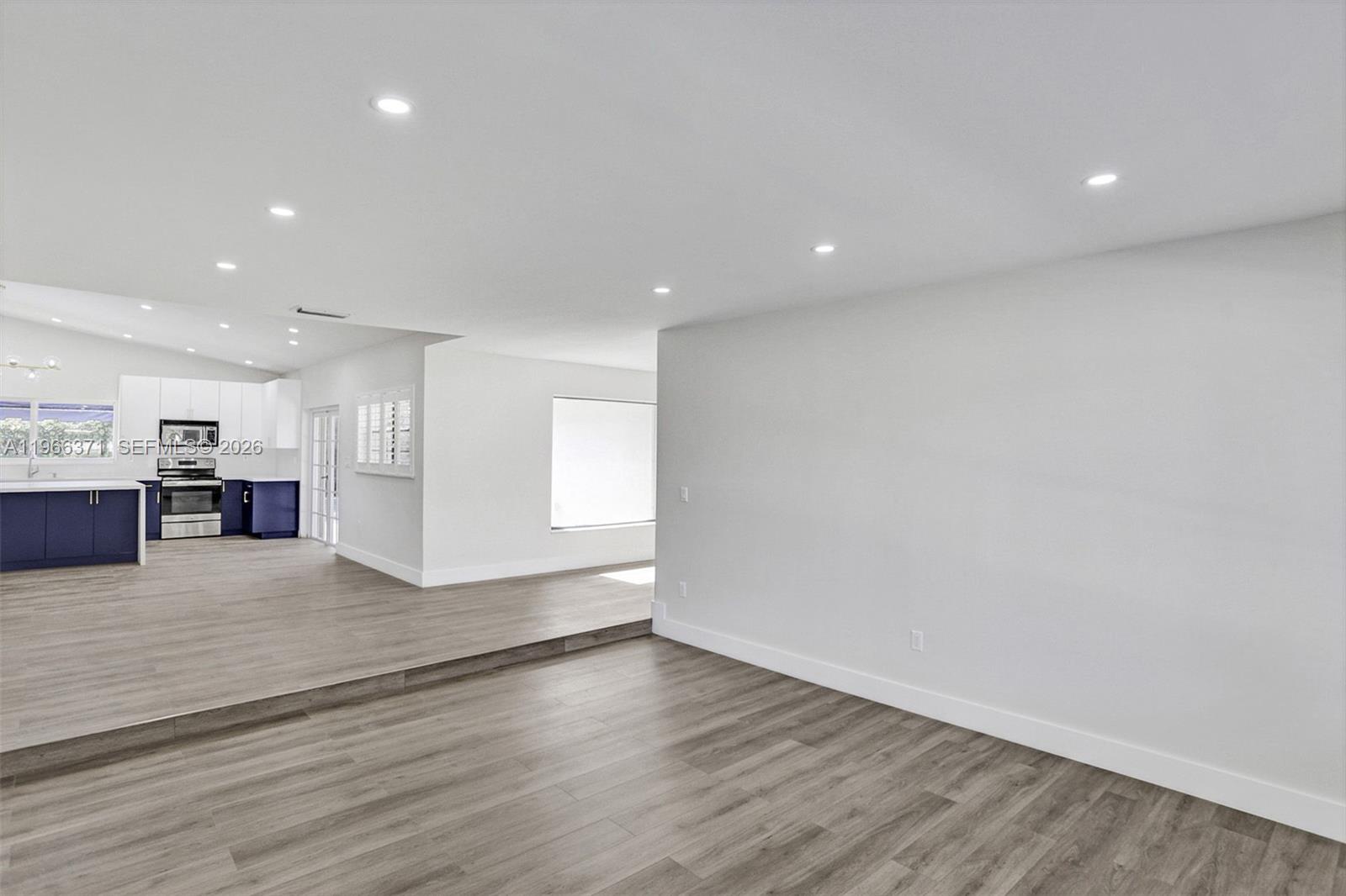 12020 Southwest 93rd Street Miami, FL 33186 - Photo 7 of 42 a view of kitchen with kitchen island a sink wooden floor and a refrigerator