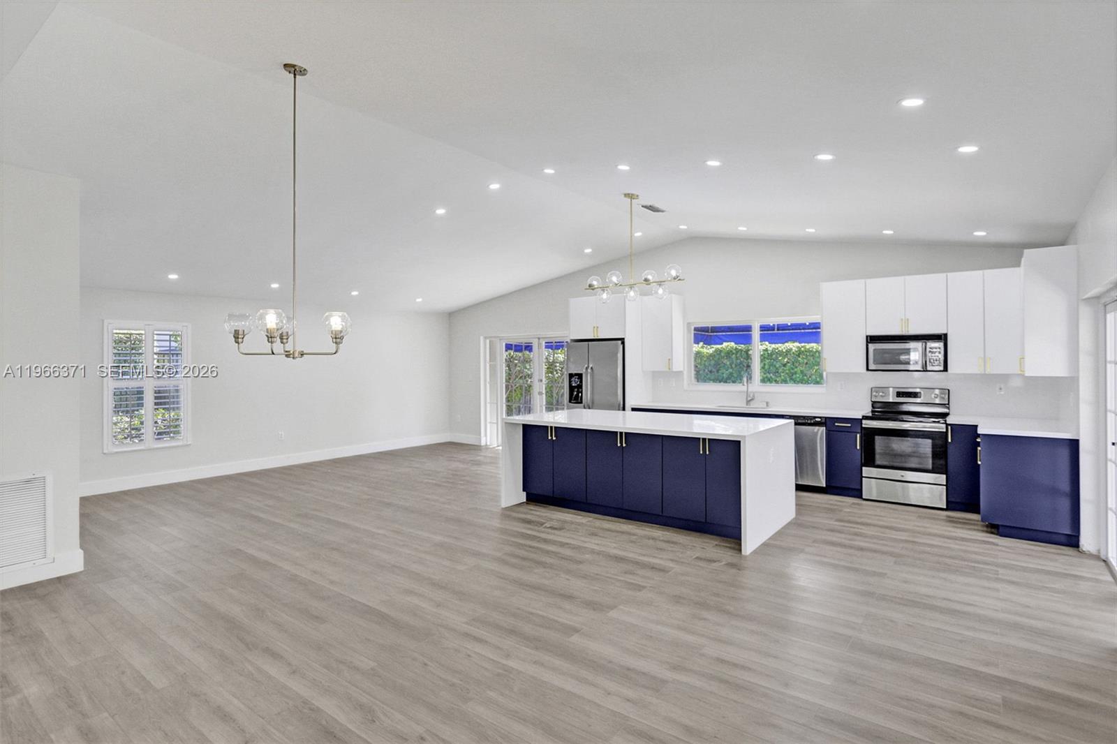 12020 Southwest 93rd Street Miami, FL 33186 - Photo 9 of 42 a kitchen with stainless steel appliances kitchen island wooden cabinets and wooden floor