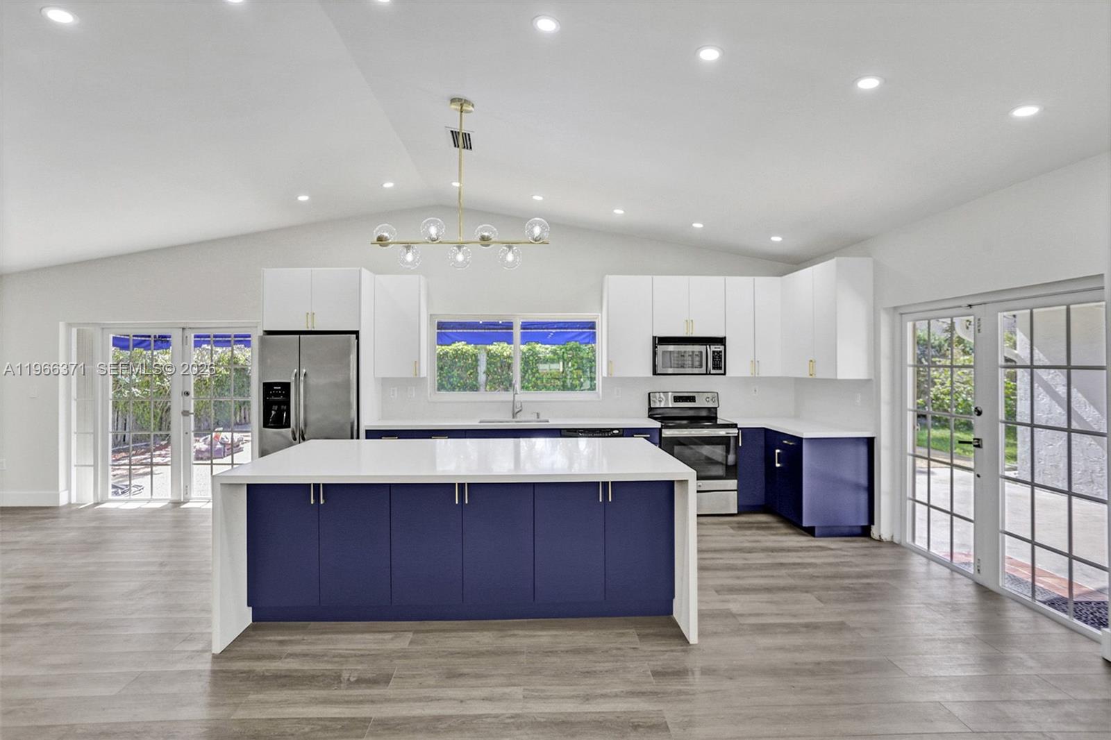 12020 Southwest 93rd Street Miami, FL 33186 - Photo 10 of 42 a kitchen with stainless steel appliances kitchen island granite countertop a stove top oven a sink dishwasher a dining table and chairs with wooden floor