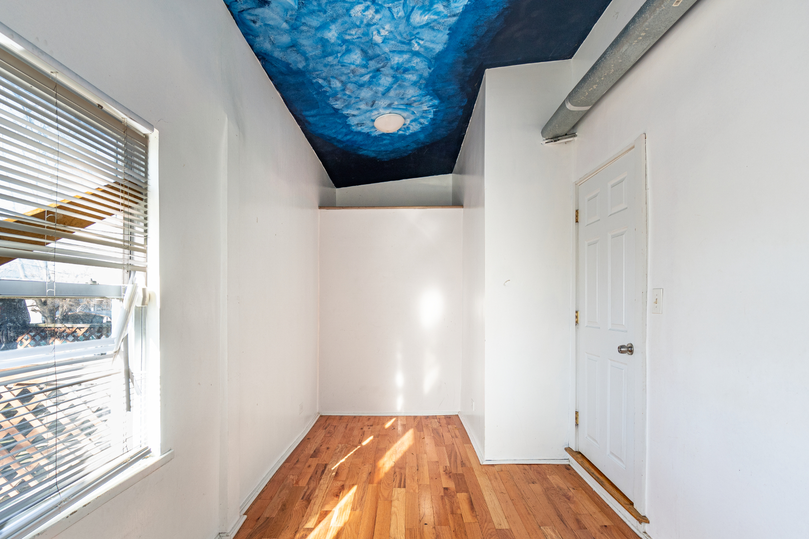 5230 South Justine Street Chicago, IL 60609 - Photo 5 of 15 a view of a bedroom with wooden floor and windows