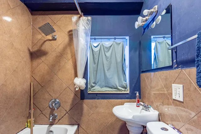 a bathroom with a sink and mirror with bathtub