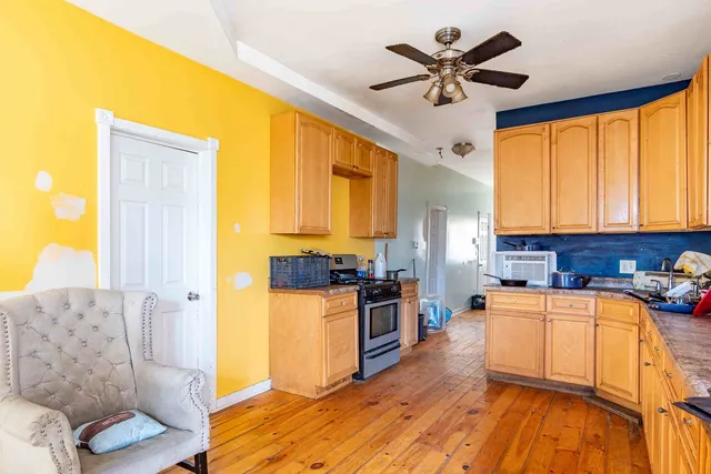 a kitchen with stainless steel appliances granite countertop a stove a sink dishwasher and a refrigerator with wooden floor