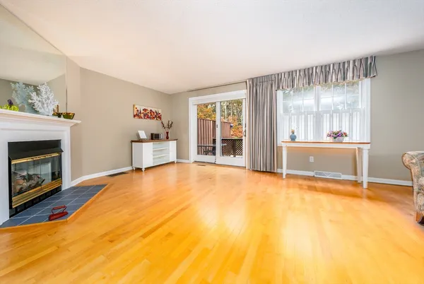 a view of an empty room with a fireplace and a window