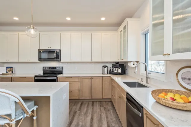 a kitchen with granite countertop a sink a counter space appliances and cabinets