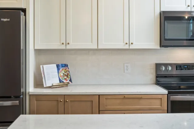 a kitchen with white cabinets and sink