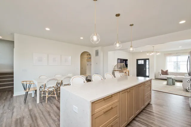 a large white kitchen with sink a table and chairs