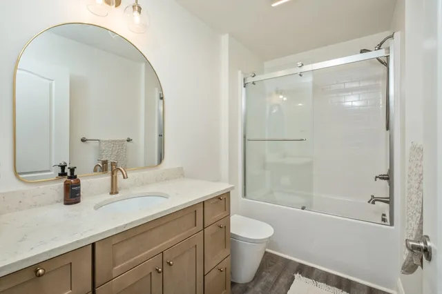 a bathroom with a granite countertop sink toilet and shower