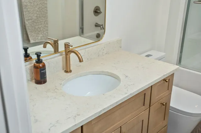 a bathroom with a granite countertop sink and a mirror