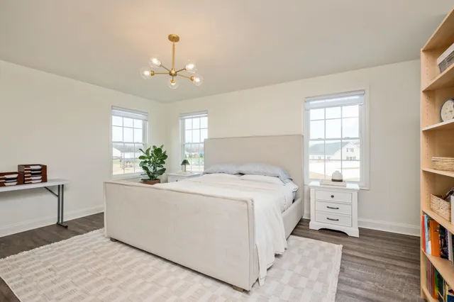 a bedroom with a large bed and a chandelier