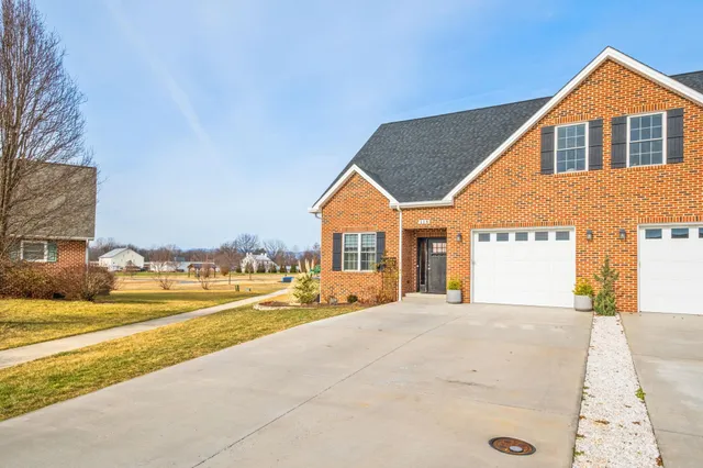 a view of a house with a yard and potted plants
