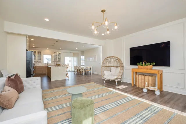 a living room with furniture a flat screen tv and kitchen view