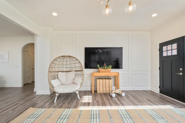 a living room with furniture a flat screen tv and a wooden floor