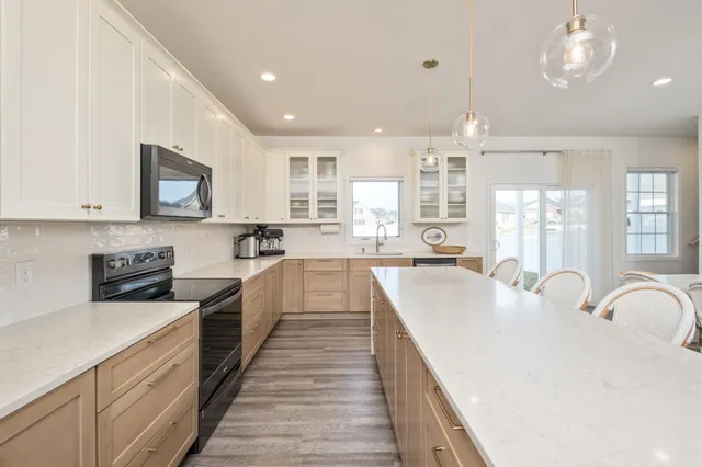 a large kitchen with kitchen island a large counter space a sink stainless steel appliances and cabinets