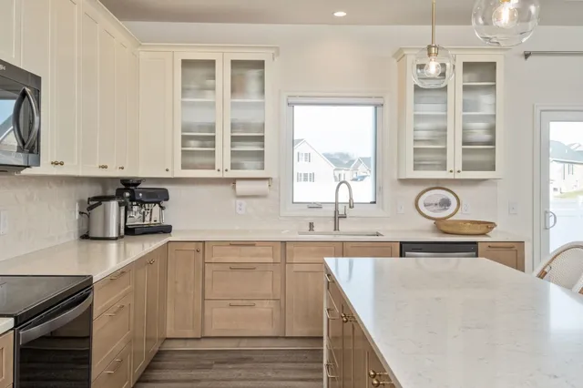 a kitchen with stainless steel appliances granite countertop a sink and cabinets with wooden floor