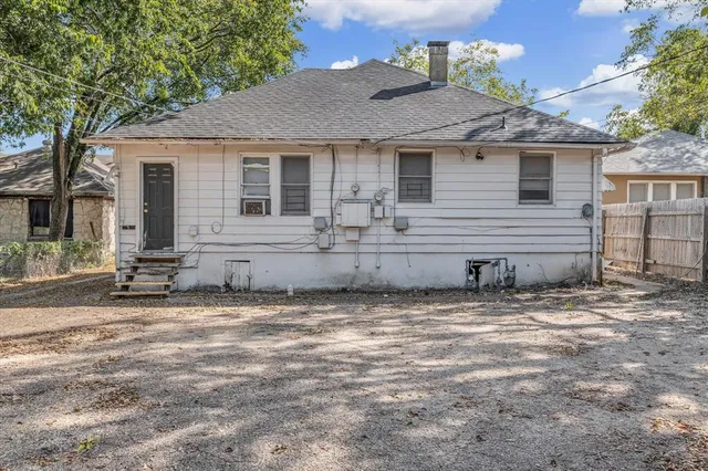 a front view of a house with a tree