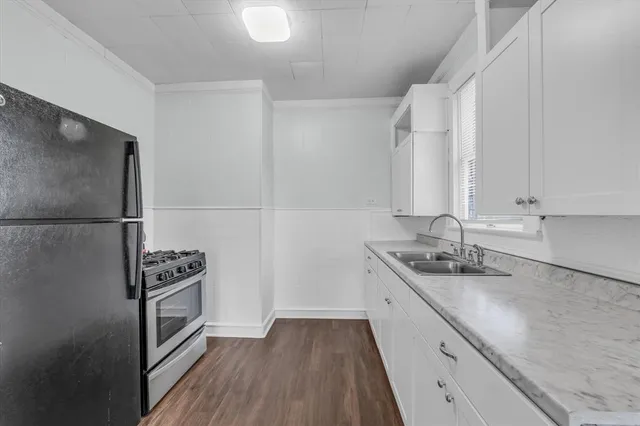 a kitchen with a sink a refrigerator a stove and cabinets