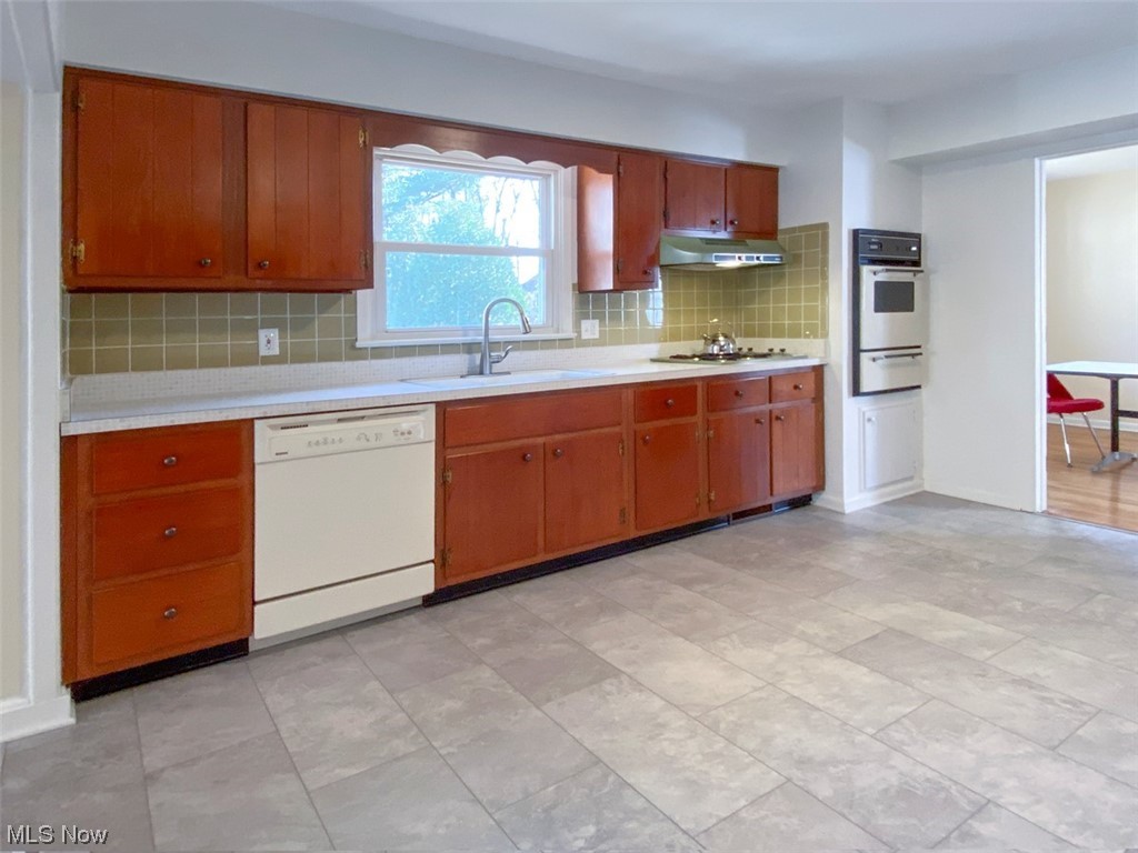 241 Jaycox Road Avon Lake, OH 44012 - Photo 6 of 26 Kitchen with light tile floors, sink, appliances with stainless steel finishes, and backsplash