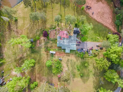 an aerial view of a residential houses with outdoor space and trees