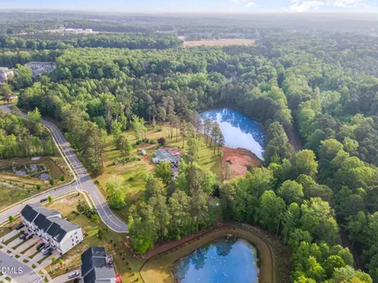 an aerial view of residential houses with outdoor space and trees
