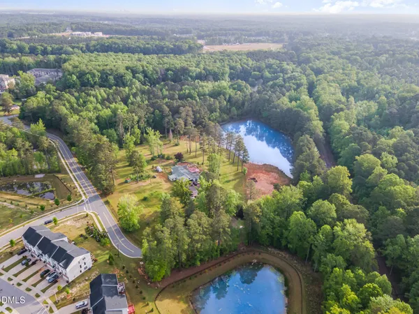 an aerial view of residential houses with outdoor space and trees