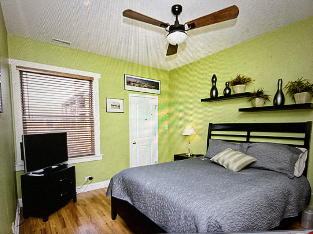 4446 North Beacon Street, Unit 3 Chicago, IL 60640 - Photo 7 of 13 a bedroom with a bed and a flat screen tv