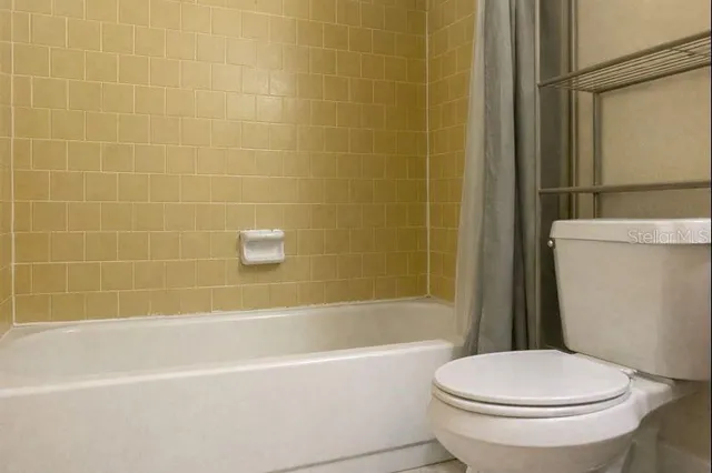 a white toilet and a bath tub sitting next to a white sink